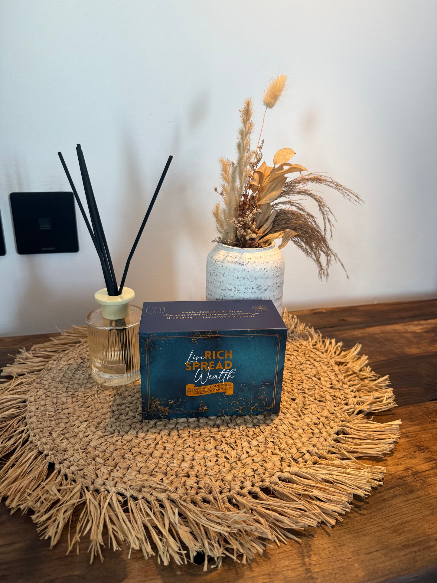Founder’s Bundle deck styled on woven mat with vase and diffuser.